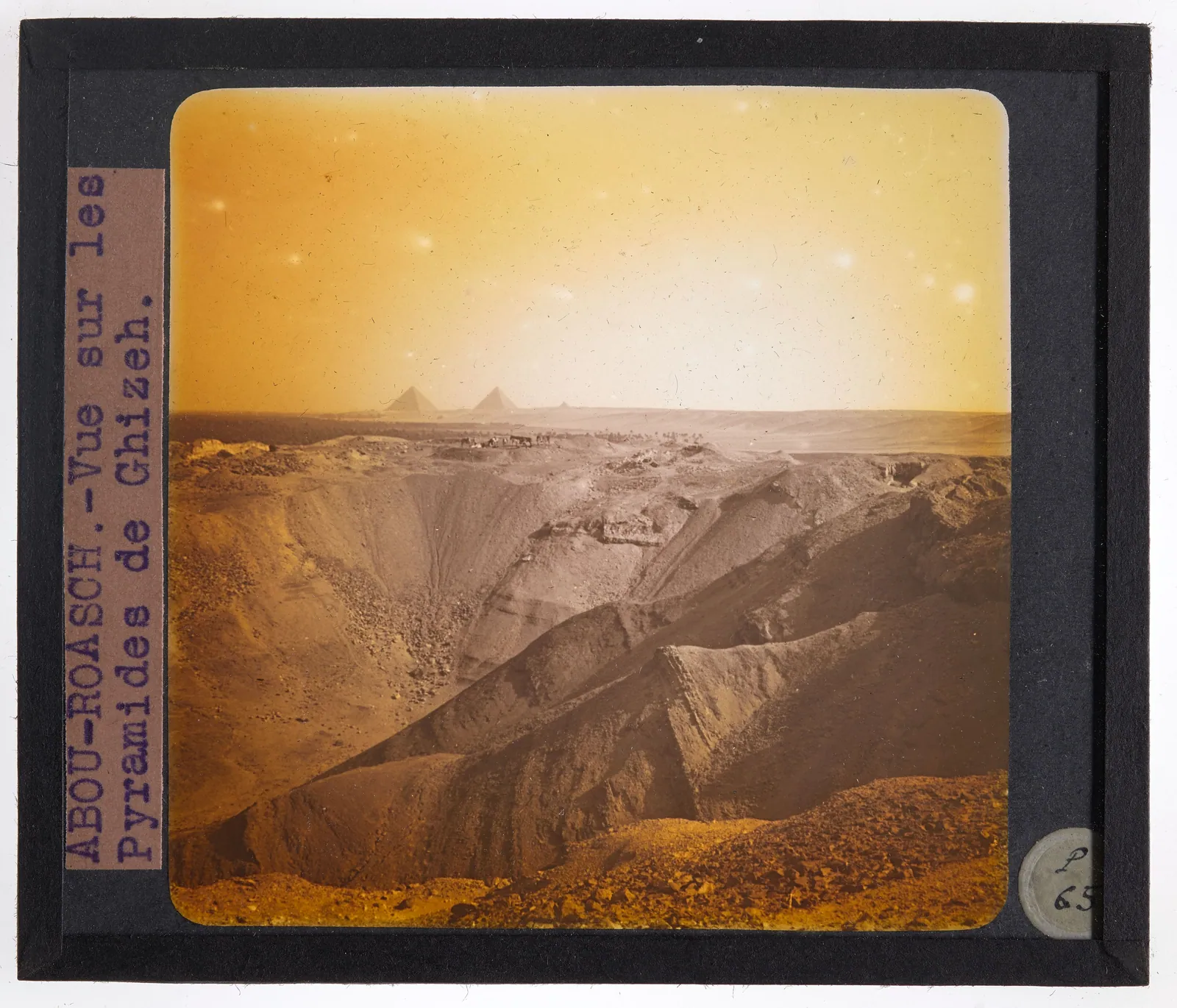”Abou-Roasch – Vue sur les pyramides de Ghizeh”: skioptikonbild från tidigt 1900-tal, tagen söderut från Abu Rawash-platån över den plundrade ruinen mot Cheops, Chefren och Mykerinos.