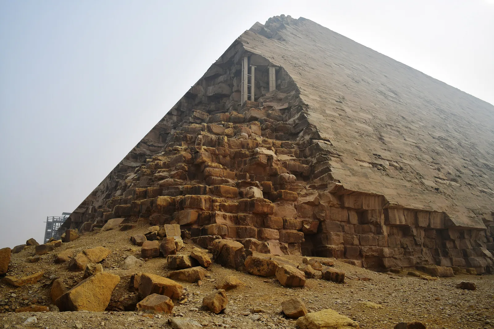 Där beklädnaden och fyllnadsstenarna har plockats bort från ett nedre hörn gapar Knäckta pyramidens inre murverk öppet. Perring skyllde en del av plundringen på Defterdar Muhammad Bey, som ville ha stenen till ett palats nära Kairo.