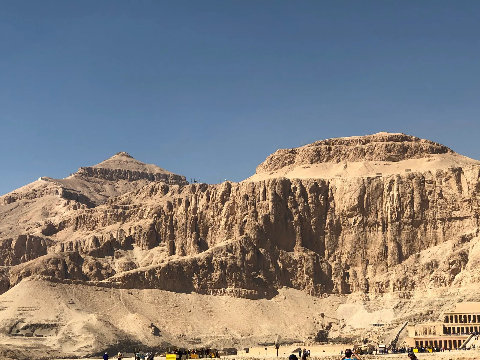 Klipporna vid Deir el-Bahari med Hatshepsuts terrasstempel vid foten (nere till höger) och den pyramidformade toppen El Qurn mot himlen.