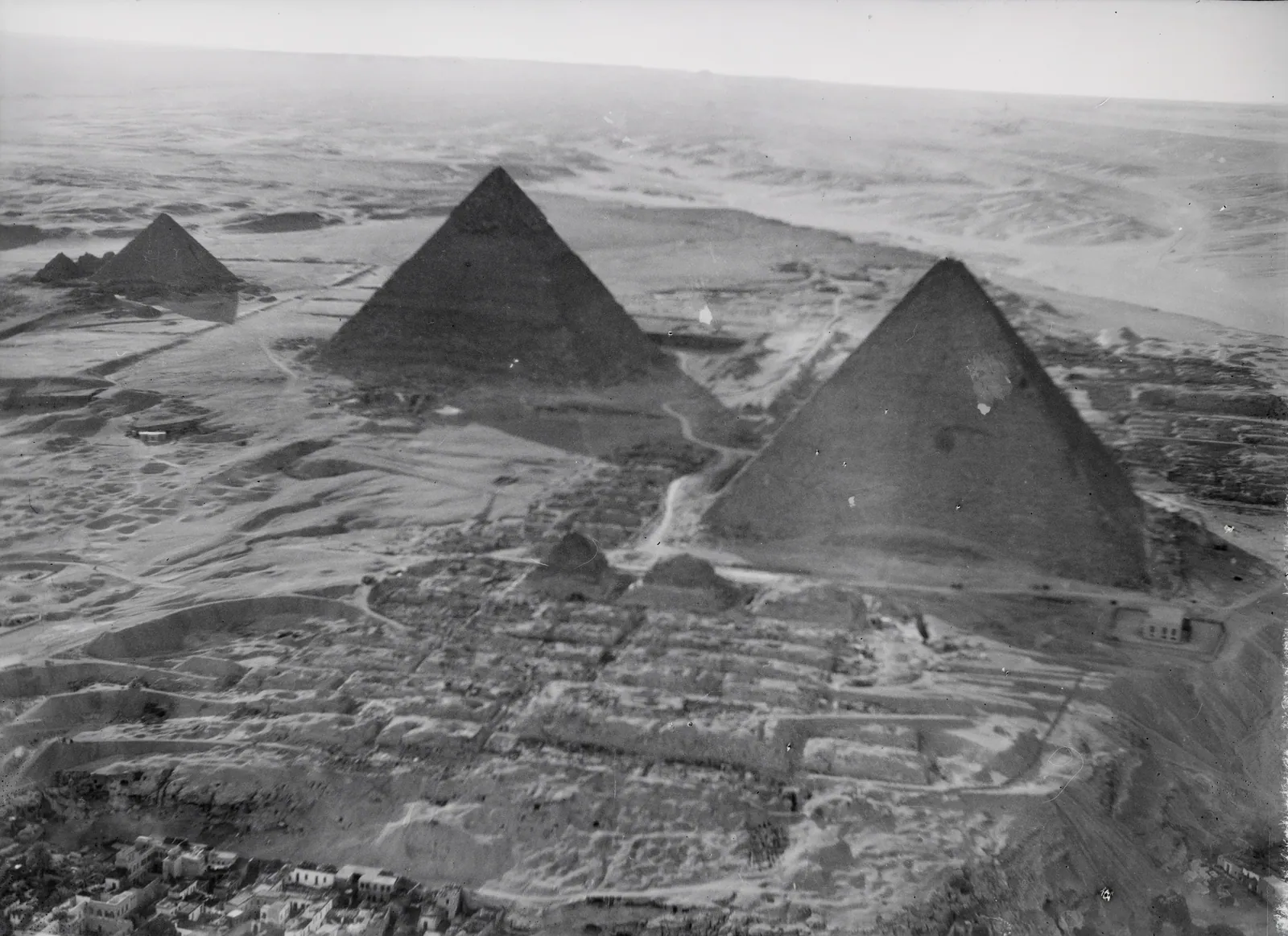 Walter Mittelholzers bild av Gizapyramiderna från cirka 400 meters höjd, tagen under hans Kilimanjaroflygning 1929–30 (ETH-biblioteket i Zürich). Den låga solen kastar de tre pyramidernas skuggor över gravfälten och stenbrotten.
