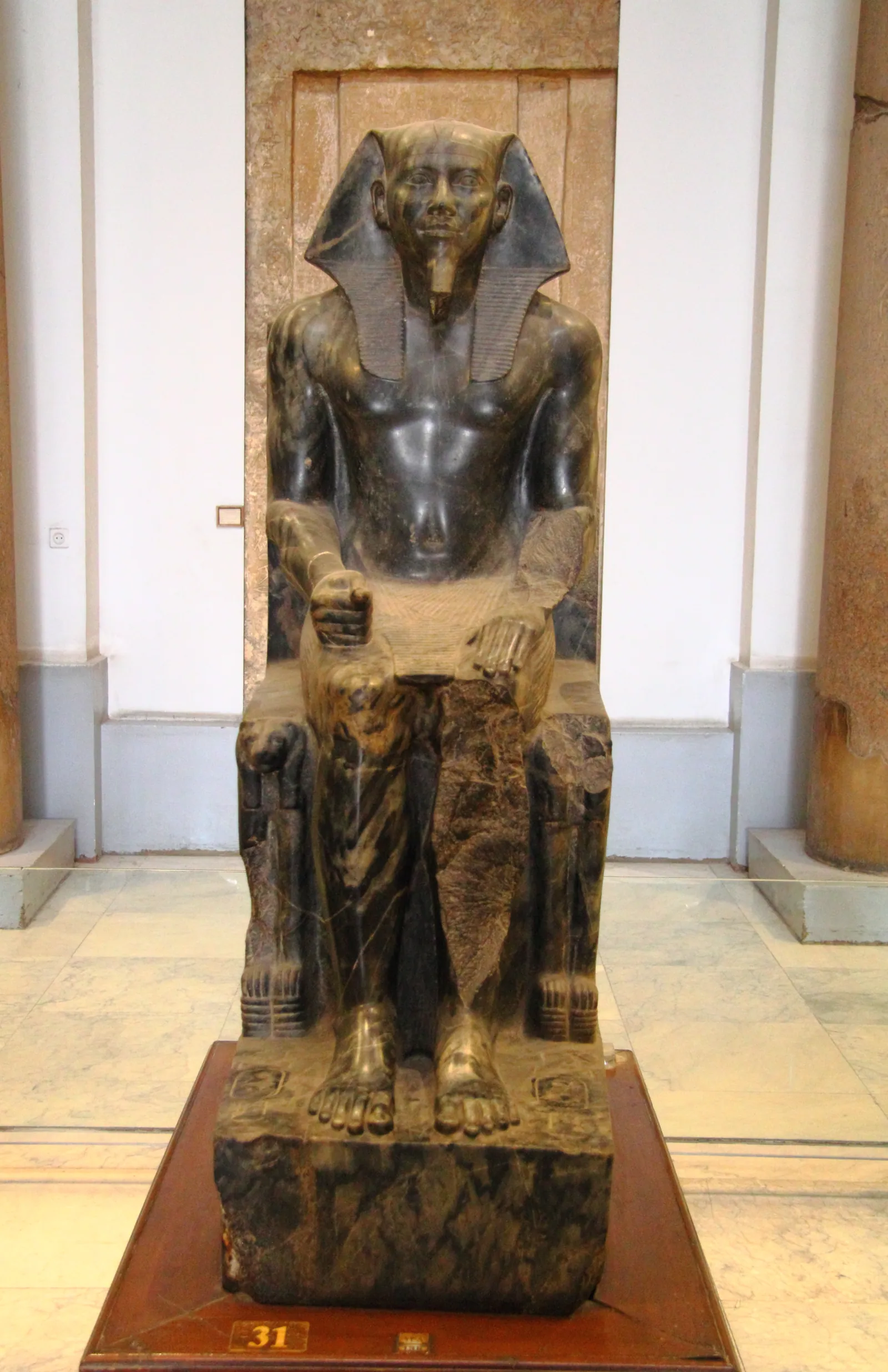 'Khafre på tronen' (Egyptiska museet i Kairo, JE 10062 / CG 14), huggen i anortositgnejs som bröts ungefär 1 000 kilometer bort i den nubiska öknen. Auguste Mariette hittade den i daltemplet 1860 (vissa källor säger 1858). Gå runt den: Horusfalken breder ut sina vingar bakom kungens huvud.