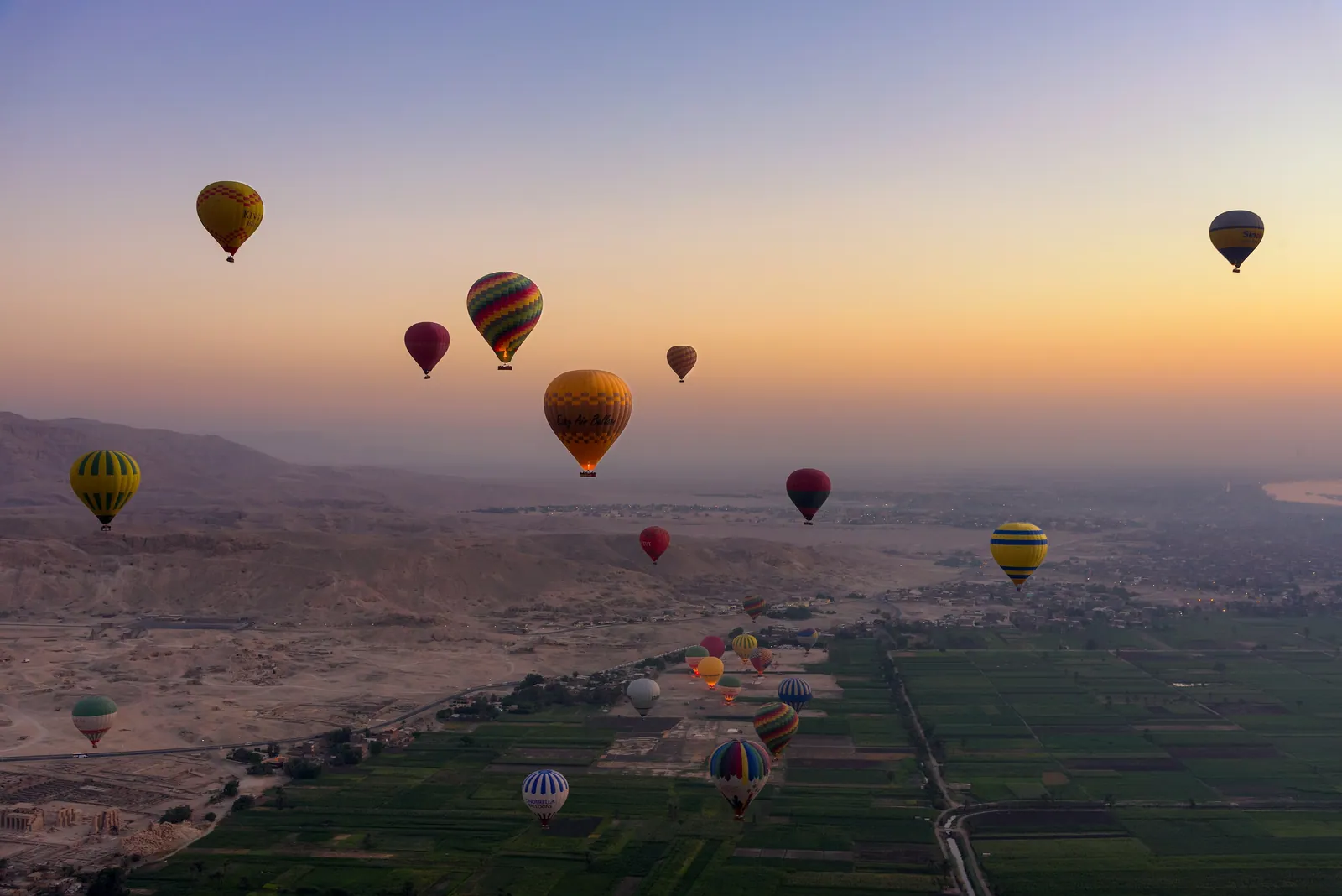 Varmluftsballonger i soluppgången över Thebes västra strand i Luxor: ökenklipporna till vänster, de gröna fälten till höger – gränsen mellan de levandes och de dödas land.