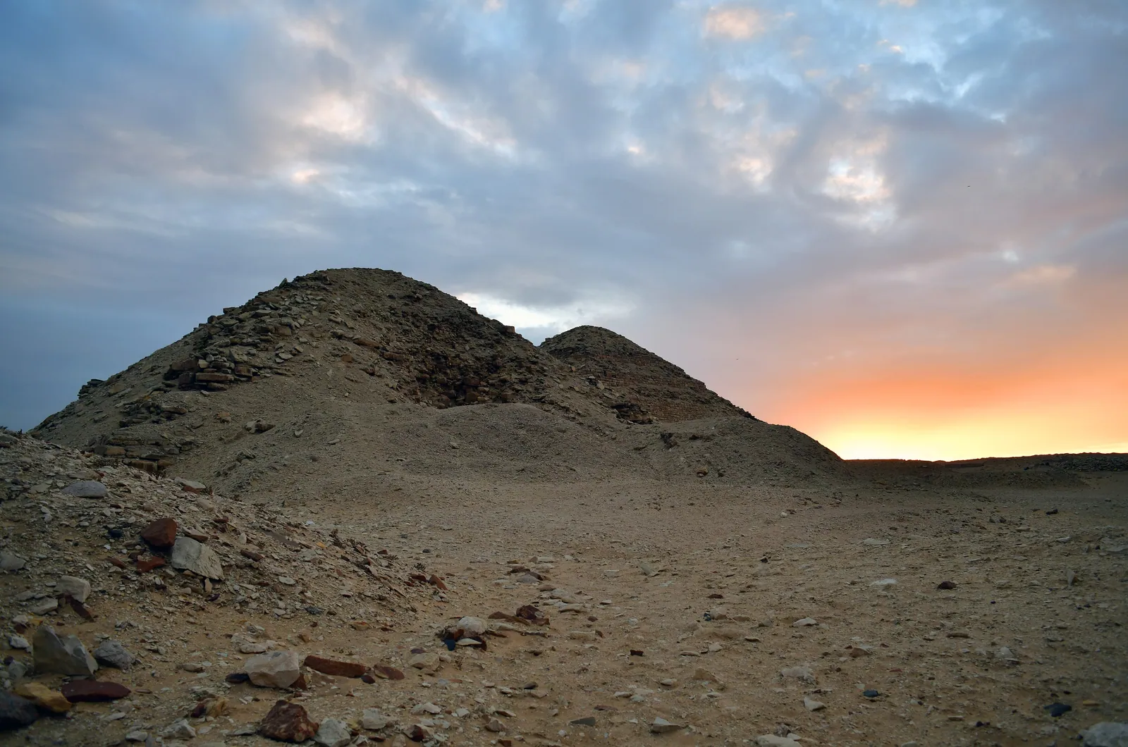 Neferirkares pyramid (den högsta i Abusir, med tydligt synlig trappstegskärna) och Niuserres pyramid i skymningen.