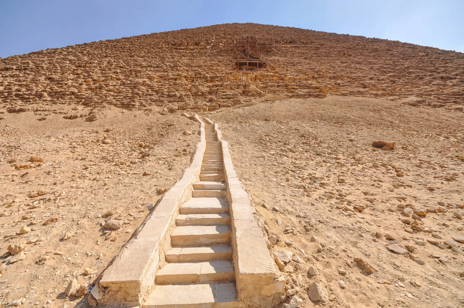 Den moderna trappan uppför nordsidan till Röda pyramidens ingång, omkring 28 meter över marken och en bit öster om mittlinjen. Räkna stegen och vänd er sedan om – därifrån har ni den bästa utsikten över Dahshur.