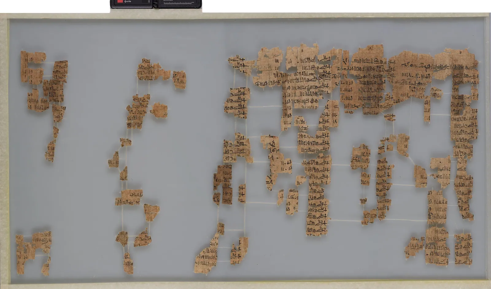 Detalj av den hopfogade Turinpapyrusen: över 160 fragment, en del bara en kvadratcentimeter stora, monterade mellan glas. Ungefär hälften av papyrusen saknas – därför står många av Gamla rikets regeringslängder bara som ”[…] år”.
