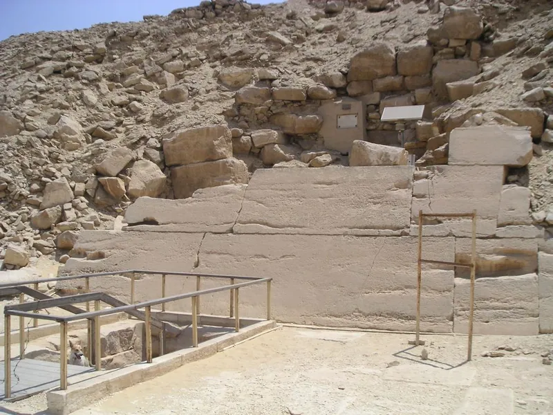 Foten av Unas pyramids nordsida: beklädnadsblock och, bakom räcket, den moderna trappan ned i den sluttande gången. På den här stenläggningen stod en gång ett litet nordkapell med en skendörr.